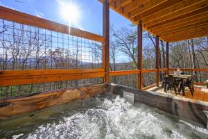 een hot tub op de veranda aan de achterzijde van een huis bij Mountain Retreat Game Room, BBQ, & Scenic Views in Sevierville