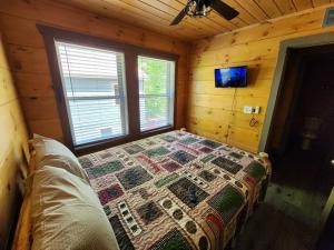 een slaapkamer met een bed in een houten hut bij Dancing Bear Cabin- Relax & Enjoy! in Sevierville