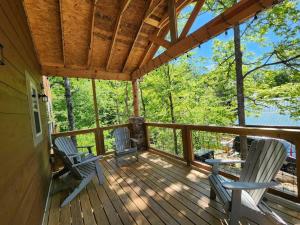 een veranda met 2 schommelstoelen en een houten dak bij Dancing Bear Cabin- Relax & Enjoy! in Sevierville