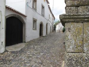 un callejón en una ciudad con edificios blancos en Casa do Castelo - Torre, en Castelo de Vide