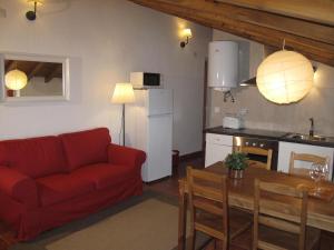 sala de estar con sofá rojo y cocina en Casa do Castelo - Torre, en Castelo de Vide