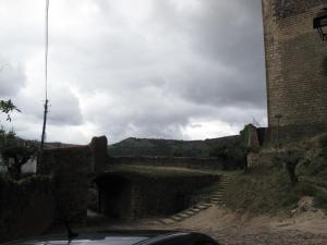 un coche conduciendo por una carretera junto a una pared de ladrillo en Casa do Castelo - Torre, en Castelo de Vide