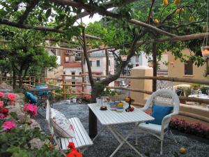 a patio with a table and chairs under a tree at Loft Apartments by AMALFIVACATION in Amalfi