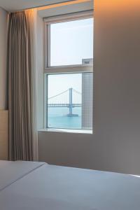 una camera da letto con finestra affacciata su un ponte di Hotel Marine view a Busan