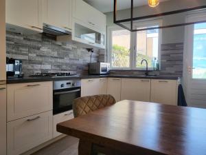 cocina con armarios blancos y mesa de madera en Boutique Hotel Huys van Leyden, en Leiden