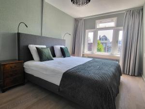 Un dormitorio con una cama grande y una ventana en Boutique Hotel Huys van Leyden, en Leiden