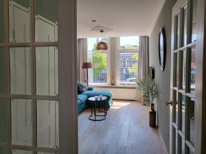 sala de estar con sofá azul y ventana en Boutique Hotel Huys van Leyden, en Leiden