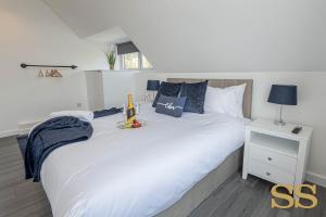 um quarto com uma grande cama branca e uma mesa de cabeceira em The Hideaway - 1 MINUTE FROM 02 ACADEMY - FREE PARKING - 5 MINUTES FROM THE BEACH - FAST WI-FI - SMART TV em Bournemouth