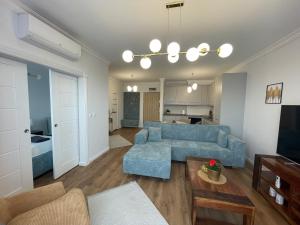 sala de estar con sofá azul y mesa en Apartament 32 NOWA WIEJSKA Olecko Mazury Garbate, en Olecko