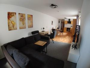 a living room with a couch and a table and a kitchen at Haus Blumenampel in Schmalkalden