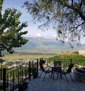 een tafel en stoelen op een patio met uitzicht bij Panoramic Vlachos in Gjirokastër