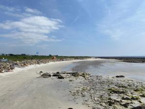 plaża z kamieniami i wodą w słoneczny dzień w obiekcie Loch Nuala w Galway