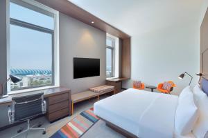 una camera d'albergo con letto e TV di Aloft Dubai Airport a Dubai