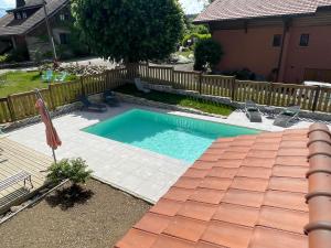 una piscina en un patio junto a una casa en Maison d'hôtes des Bassins d'Oche, en Saint-Paul-en-Chablais