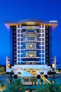 een gebouw met een zwembad ervoor bij Le Meridien Coimbatore in Coimbatore