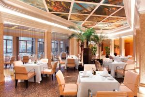 un restaurante con mesas blancas, sillas y techos en Sheraton Shenzhen Futian Hotel, Close to Metro Station, Shenzhen Futian Convention & Exhibition Centre, Futian Railway Station en Shenzhen