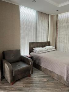 una camera con letto e sedia di Villa Old Batumi a Batumi