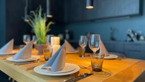 - une table en bois avec des assiettes et des verres à vin dans l'établissement InkBlue-Apartment, à Heidenau