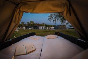 a bed in a tent with a book on it at Marina Martinshafen - Beach life in Sassnitz