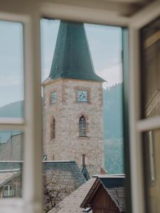 een gebouw met een toren met een klok erop bij SIEGLGUT in Altaussee