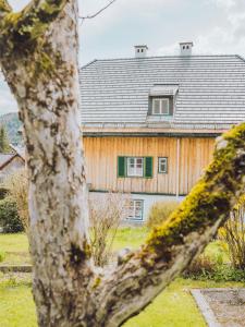 een huis met een grijs dak en groene ramen bij SIEGLGUT in Altaussee