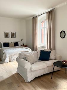 - un salon avec un canapé blanc et un lit dans l'établissement Lawenda Apartamenty Boutique, à Kudowa-Zdrój