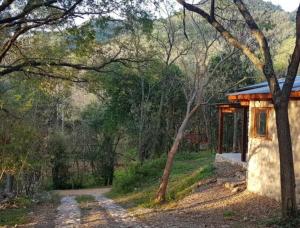 uma pequena casa no meio de uma estrada de terra em Las Casitas de Piedra I em Villa General Belgrano