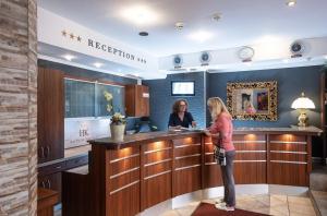 Due donne in piedi in un bar nella hall di un hotel di Hotel Kufsteinerhof a Kufstein