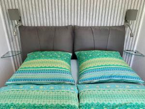 1 cama con 2 almohadas y 2 mesas en AnNa Home & Sunny Home Apartments, en Karlsruhe