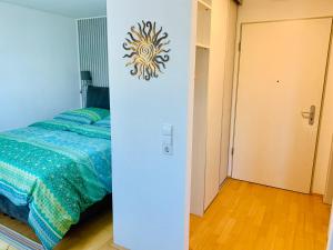 1 dormitorio con 1 cama y pared con reloj en AnNa Home & Sunny Home Apartments, en Karlsruhe