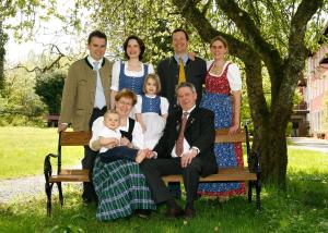 Eine Familie, die für ein Bild auf einer Bank posiert. in der Unterkunft Hotel Johannisbad in Bad Aibling