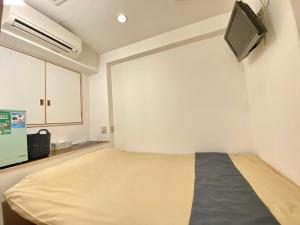 um quarto de hospital com uma cama e uma televisão em Tabist Hotel Aurora Ikebukuro em Tóquio