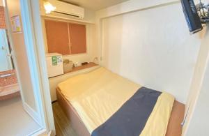 um pequeno quarto com uma cama e um micro-ondas em Tabist Hotel Aurora Ikebukuro em Tóquio