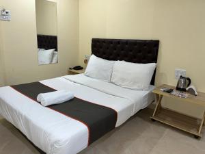 a bedroom with a large bed with a black headboard at U LIFE HOTEL in Mumbai