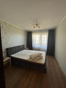 a bedroom with a large bed with a window at Atmodas 70 in Jelgava