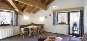 una sala da pranzo con tavolo, sedie e finestre di Pension Wendlhof a Obergurgl