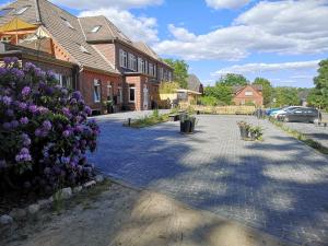 eine Kopfsteinpflasterstraße in einem Wohngebiet mit lila Blumen in der Unterkunft Gästehaus Maria Rast in Suderburg