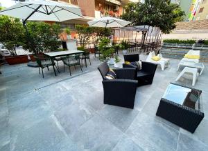 een patio met stoelen, tafels en parasols bij Hotel Franchi in Florence