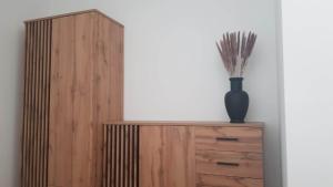 een houten kast met een vaas erop bij Apartament Flat 33 Suwałki in Suwałki