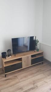 een flatscreen-tv op een houten entertainmentcentrum bij Apartament Flat 33 Suwałki in Suwałki