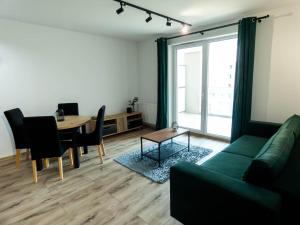 een woonkamer met een groene bank en een tafel bij Apartament Flat 33 Suwałki in Suwałki