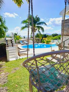 a swing in front of a swimming pool at Residence Ma Vie Là Ltee in Le Morne