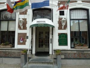 ein Hotel mit Flaggen vor einem Gebäude in der Unterkunft Hotel Centraal in Harlingen