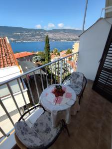 una mesa y sillas en un balcón con vistas al océano en Smestaj Vella, en Herceg-Novi