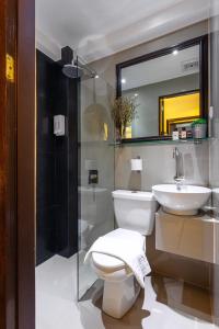 ein Badezimmer mit einem WC, einem Waschbecken und einem Spiegel in der Unterkunft Nest Nano Suites Poblacion - Makati in Manila