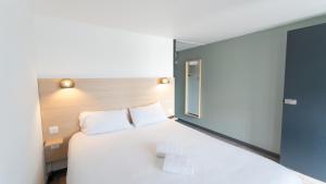 een slaapkamer met een groot wit bed en een raam bij Hotel Inn Design La Rochelle in La Rochelle