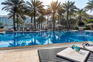 een groot zwembad met palmbomen in een resort bij Al Raha Beach Hotel in Abu Dhabi