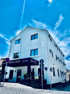 um edifício branco na esquina de uma rua em Side One Design Hotel Garni em Belgrado