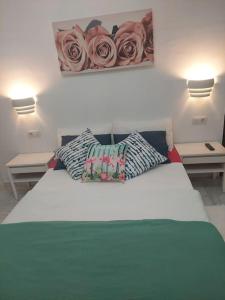 um quarto com uma cama com dois candeeiros e rosas na parede em Central apartment in Arrecife - 1 or 2 bedrooms em Arrecife