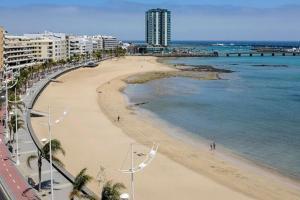 uma vista para uma praia com edifícios e o oceano em Central apartment in Arrecife - 1 or 2 bedrooms em Arrecife